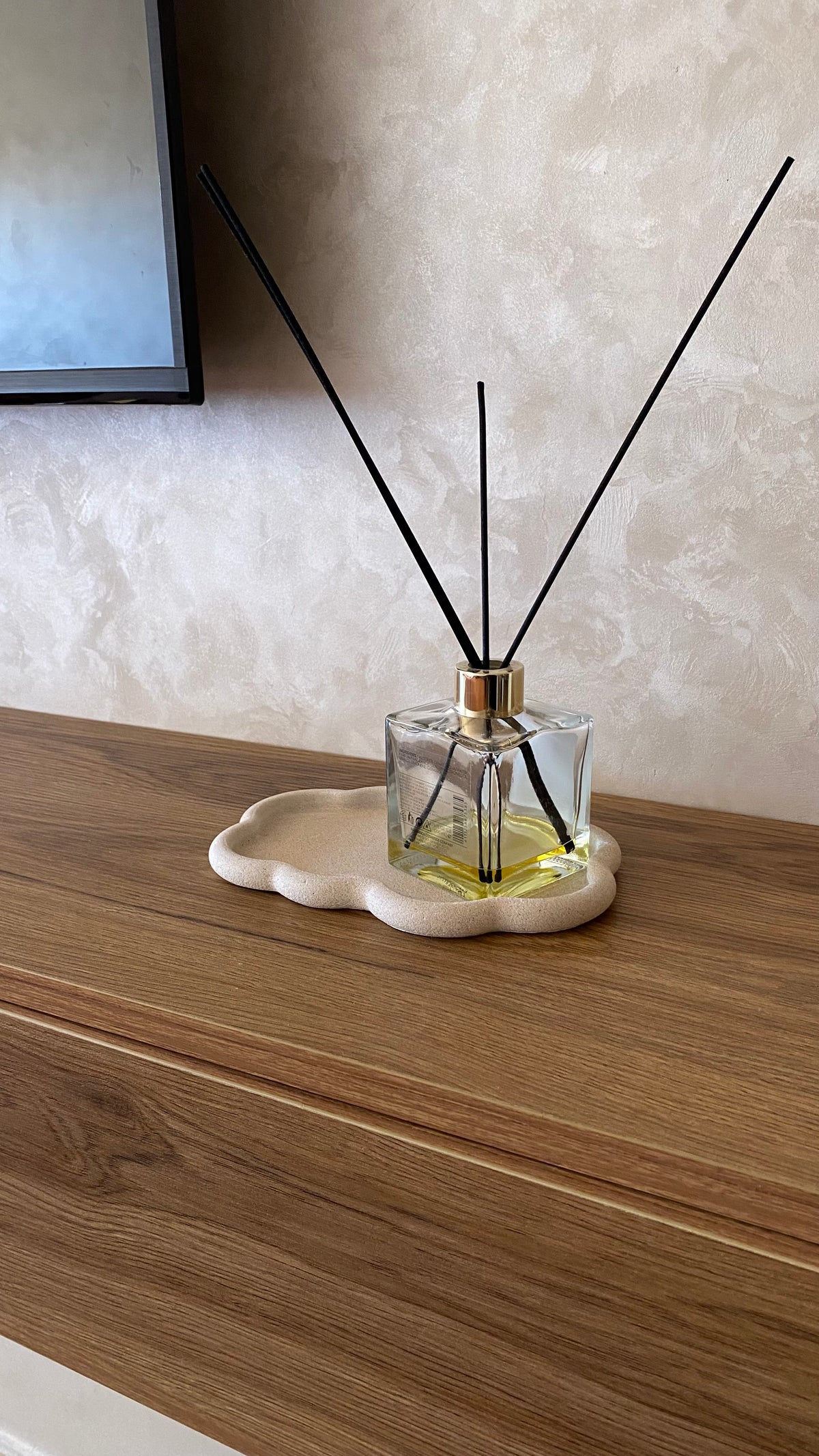 Plateau en jesmonite beige sur une table murale en bois
