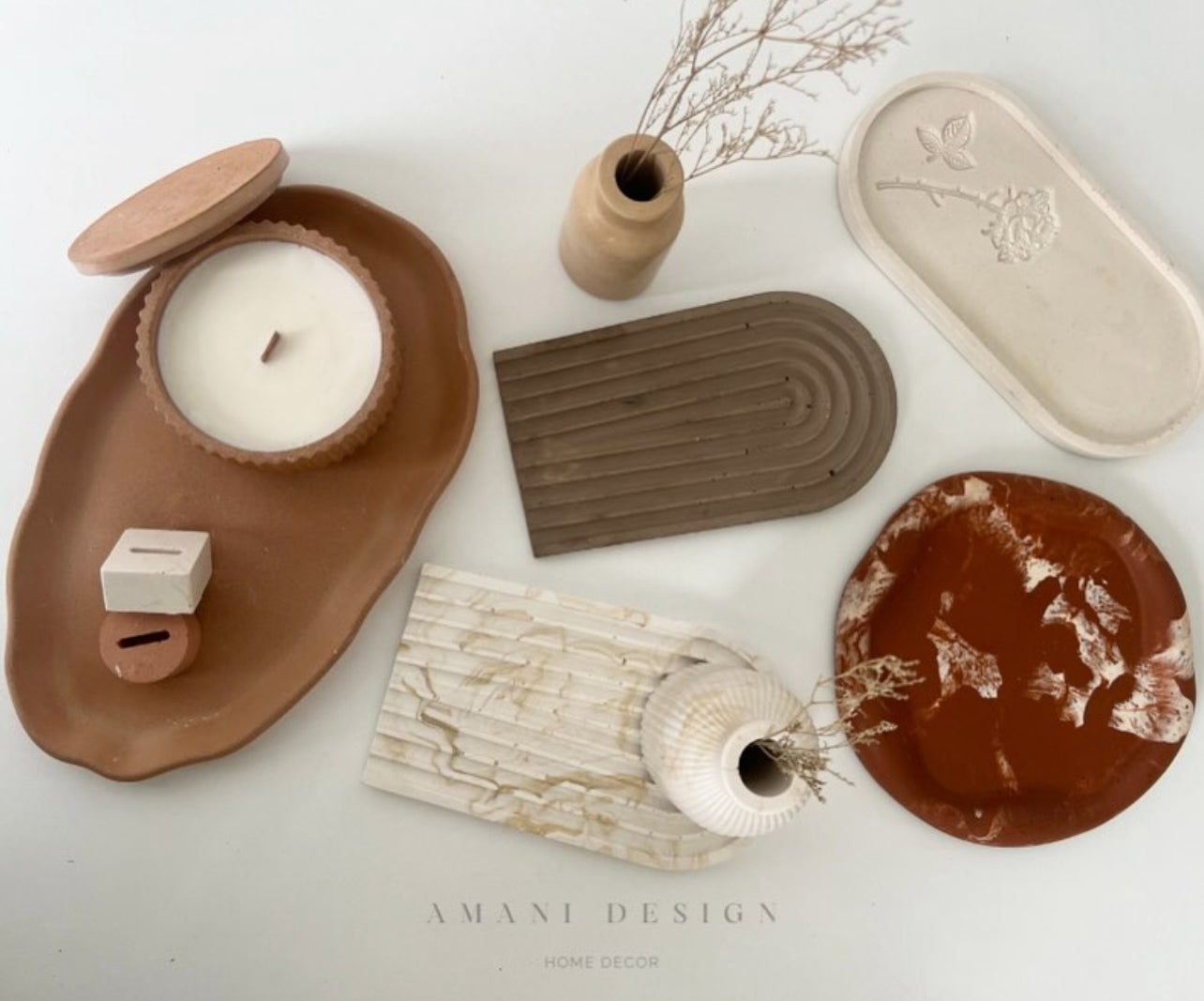 Objets en jesmonite exposés sur un fond blanc (il ya un vase, des plateaux décoratifs)