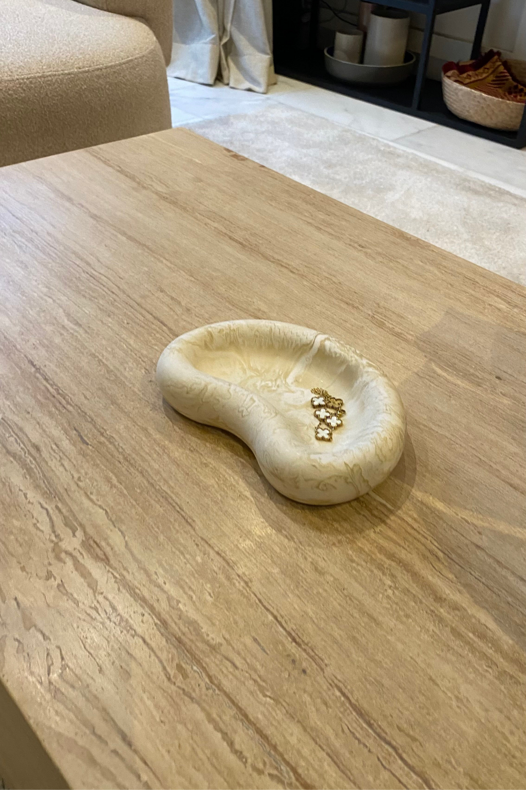 Plateau en jesmonite de la marque AMANI DESIGN en beige marbré posé sur une table en bois