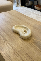 Plateau en jesmonite de la marque AMANI DESIGN en beige marbré posé sur une table en bois