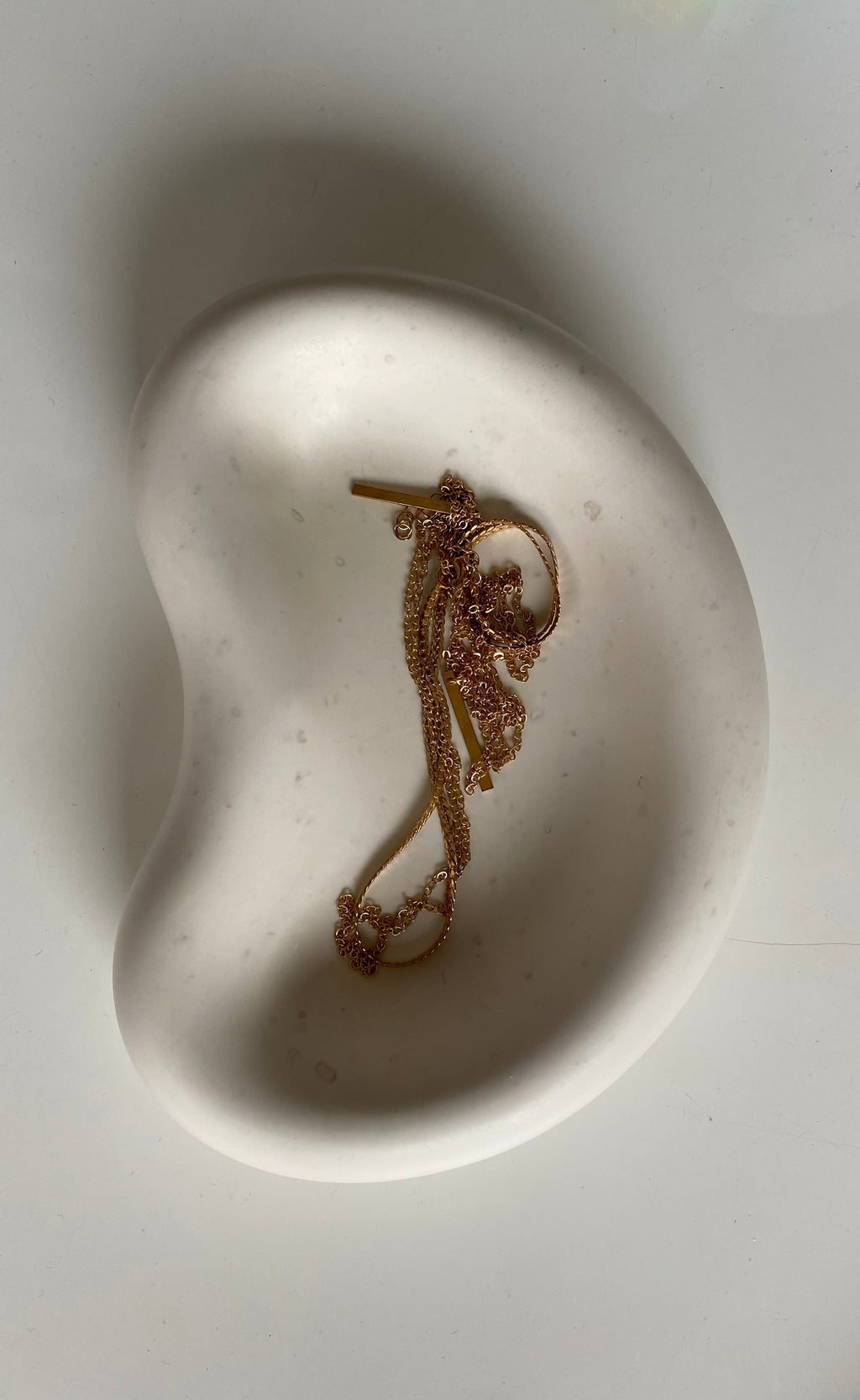 plateau blanc en jesmonite avec un collier dedans