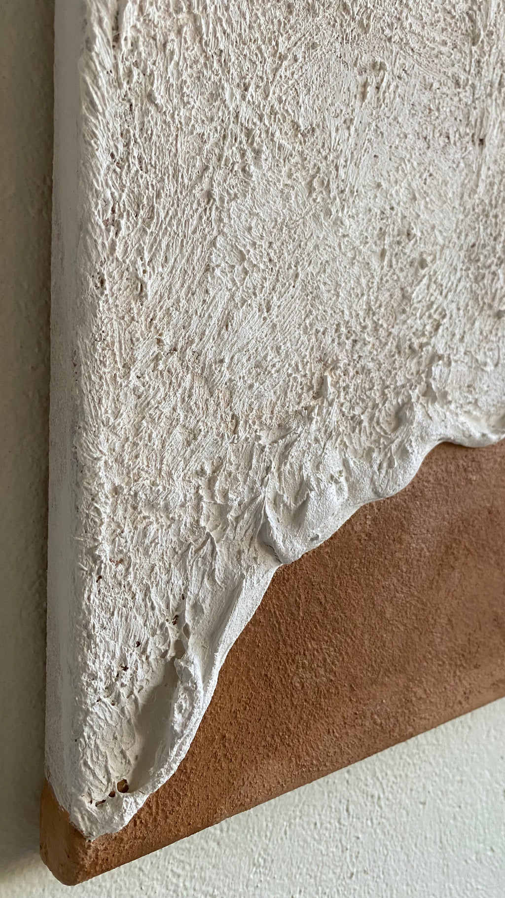 Tableau texturé inspiré des vagues, zoomé sur les bords aux reliefs ondulés et aux tons naturels beige et sable. Œuvre murale minimaliste et organique apportant une atmosphère apaisante à un intérieur contemporain.