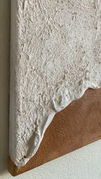 Tableau texturé inspiré des vagues, zoomé sur les bords aux reliefs ondulés et aux tons naturels beige et sable. Œuvre murale minimaliste et organique apportant une atmosphère apaisante à un intérieur contemporain.